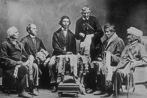 Photographie noir et blanc montrant six hommes (cinq assis et un debout), dans la pose d'un portrait officiel