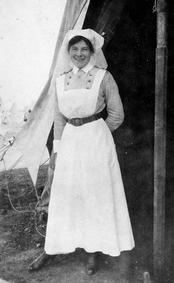Photograph of Ruby Peterkin in uniform, standing in front of a tent